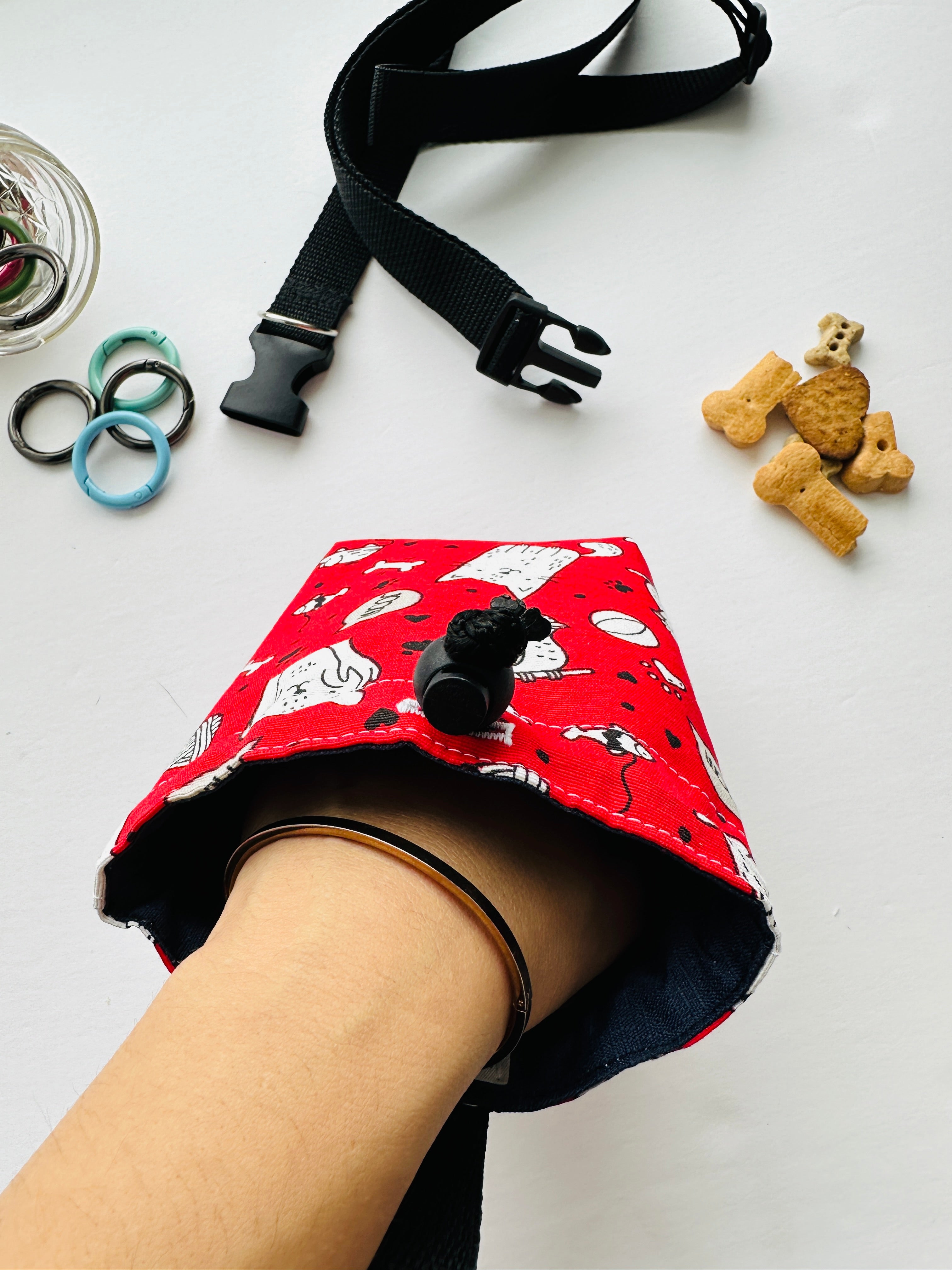 Red  pouch with hand reaching for treats